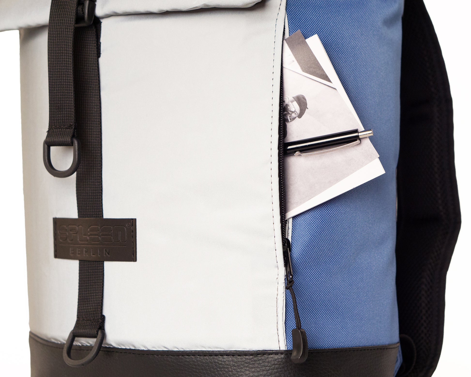 Fahrradrucksack Bob Ice Blue mit Rolltop –Detailansicht der reflektierenden Frontasche mit versteckter Reißverschlußtasche seitlich,  minimalistisches Design, vegan, wasserabweisend, von Spleen Berlin  
© Spleen Berlin