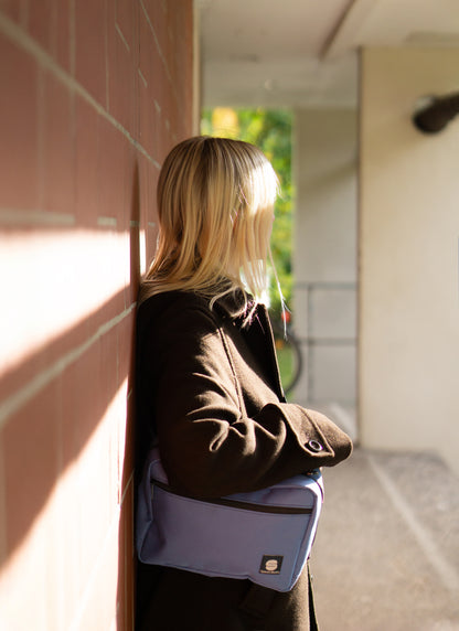 Stylische Crossbody-Bag Ice Blue von Spleen Berlin – moderne Umhängetasche für Alltag & Fahrrad, getragen von einer blonden Frau im urbanen Stil. 
@Spleen Berlin