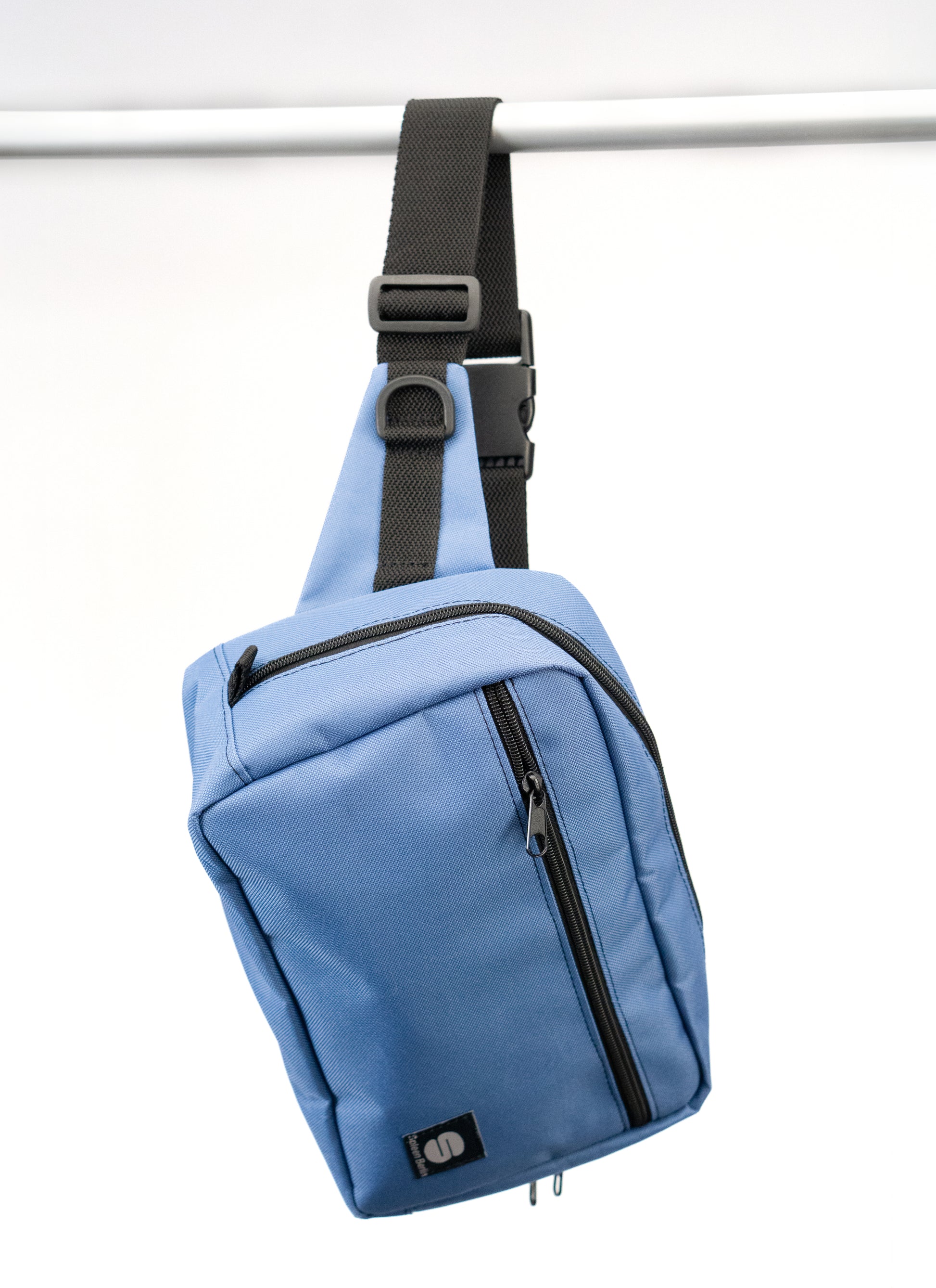 Seitliche Ansicht der hellblauen Crossbody-Bag „Iceblue“ von Spleen Berlin mit sichtbarem Zipper; stylische, vegane 3,5-Liter-Umhängetasche im urbanen Look, auch als Lenkertasche fürs Fahrrad nutzbar. @Spleen Berlin