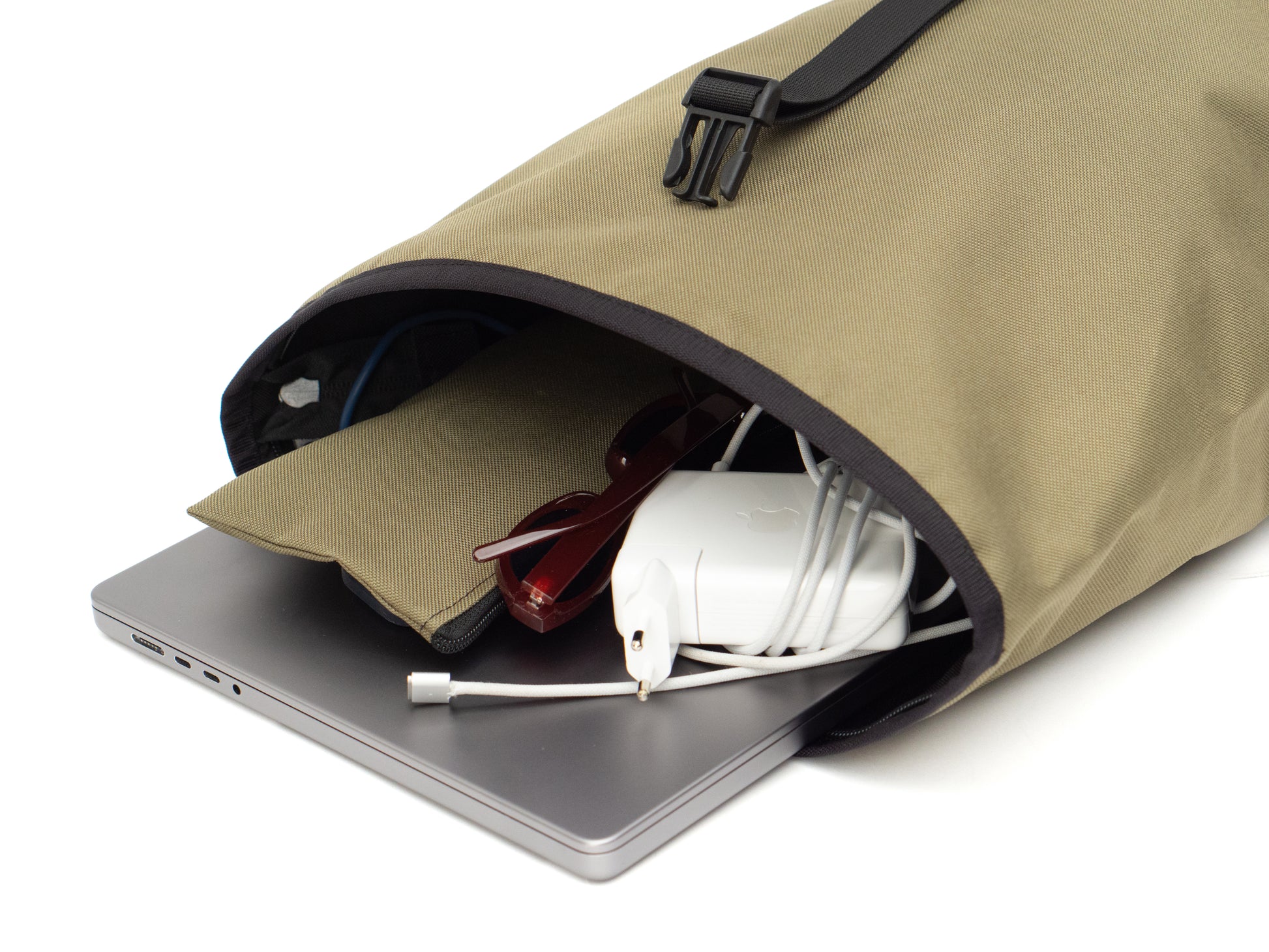 Fixie - Olive von Spleen Berlin in der Innenansicht, liegend geöffnet mit eingestecktem Laptop, Sonnenbrille und kleinem Täschchen. Viel Platz & durchdachte Organisation für unterwegs. ©Spleen Berlin