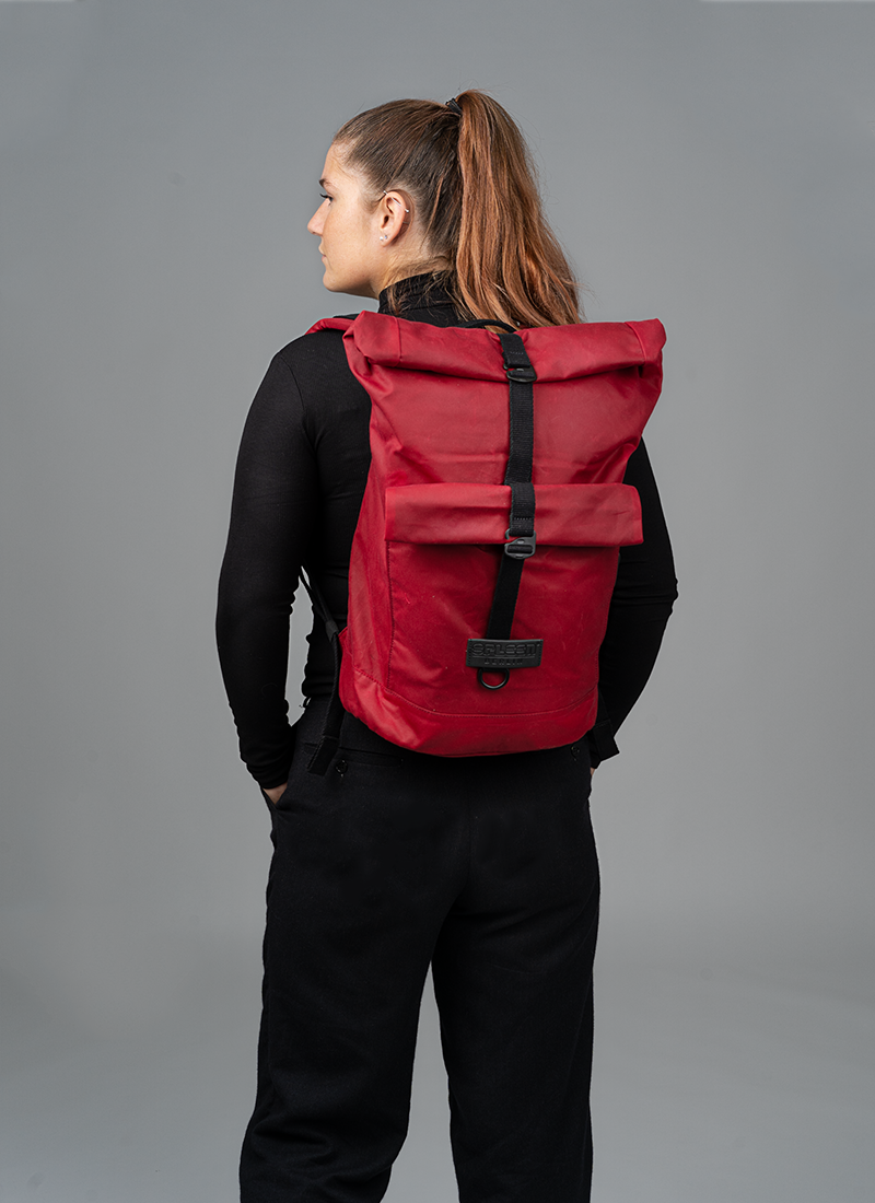 Bob - waxed Cotton red Rucksack aus gewachster Baumwolle in Rot, getragen von einem jungen Frau zur Größenansicht veganer Tagesrucksack, ideal für Uni, Stadt  oder Freizeit. ©Spleen Berlin